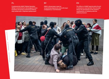 Fotografia z wystawy Białoruś. droga do wolności. funkcjonariusze oddziału specjalnego milicji w kominiarkach brutalnie zatrzymują protestujące kobiety. dwie leżą na ziemi, pozostałe stoją pod szarym murem.